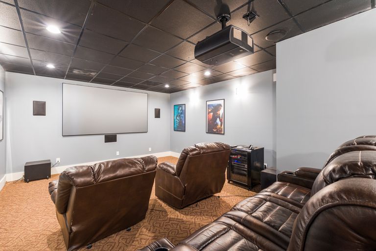Cozy home theater setup with plush leather recliners and modern audiovisual equipment.